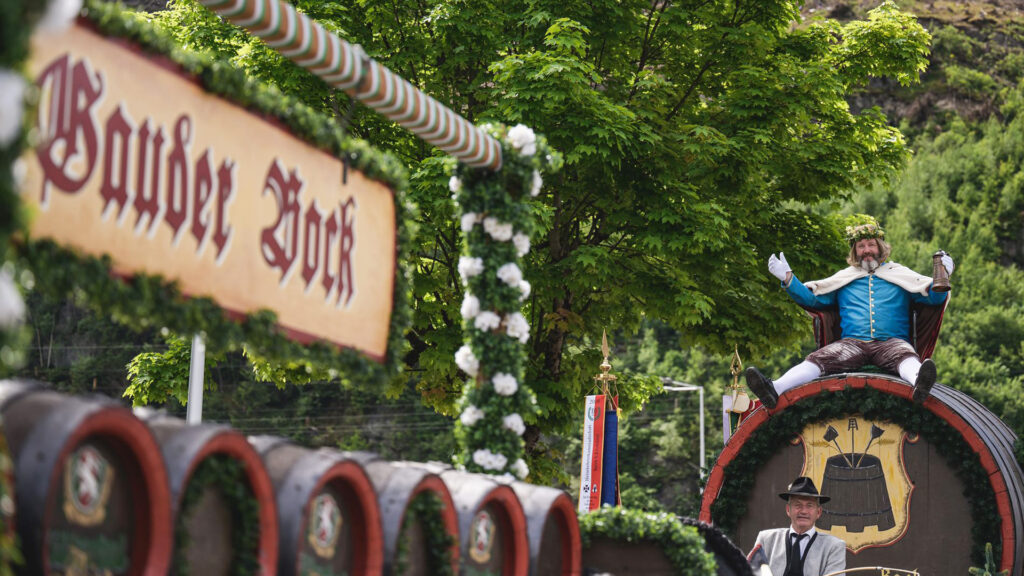 Events Österreich: Festwagen und Trachtengruppe beim traditionellen Gauder Fest in Tirol mit dekorierten Bierfässern.