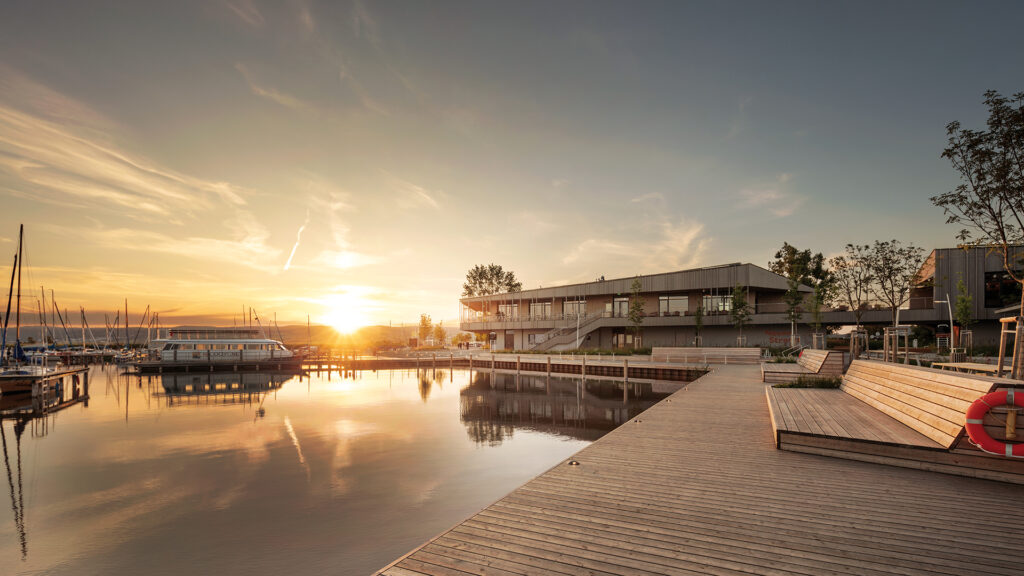 Restaurant Libelle: Sonnenuntergang am Hafen mit entspannter Atmosphäre und Blick auf das Restaurant am Wasser.