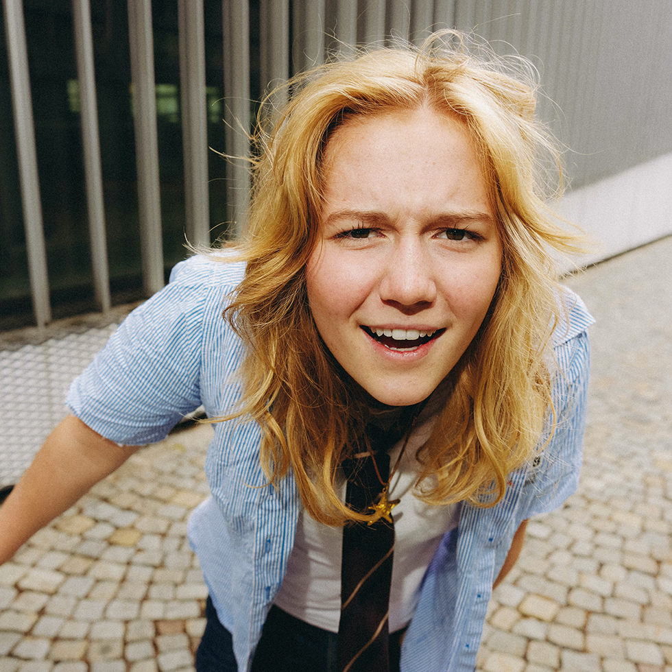 Churro64: Luisa Schweig bei einem urbanen Fotoshooting mit direktem, skeptischem Blick in die Kamera.