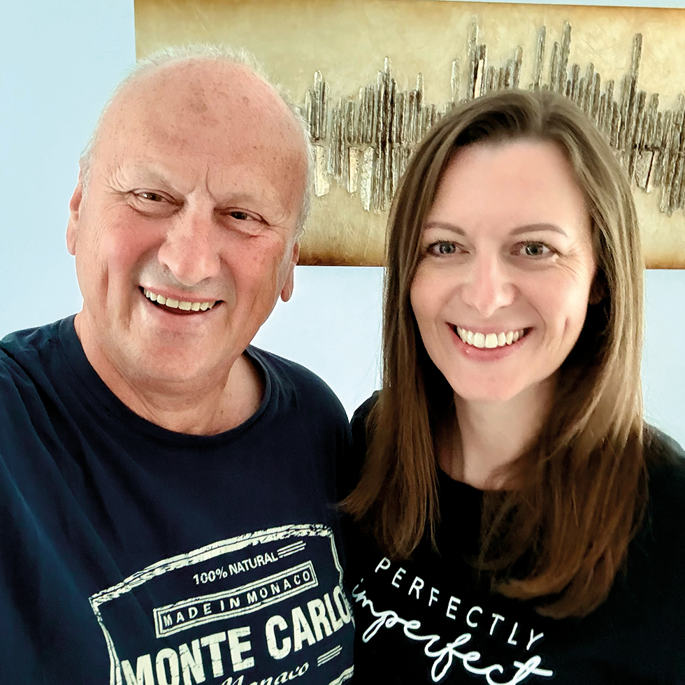 Vater und Tochter lächeln gemeinsam in die Kamera bei einem Familienfoto zum Vatertag.