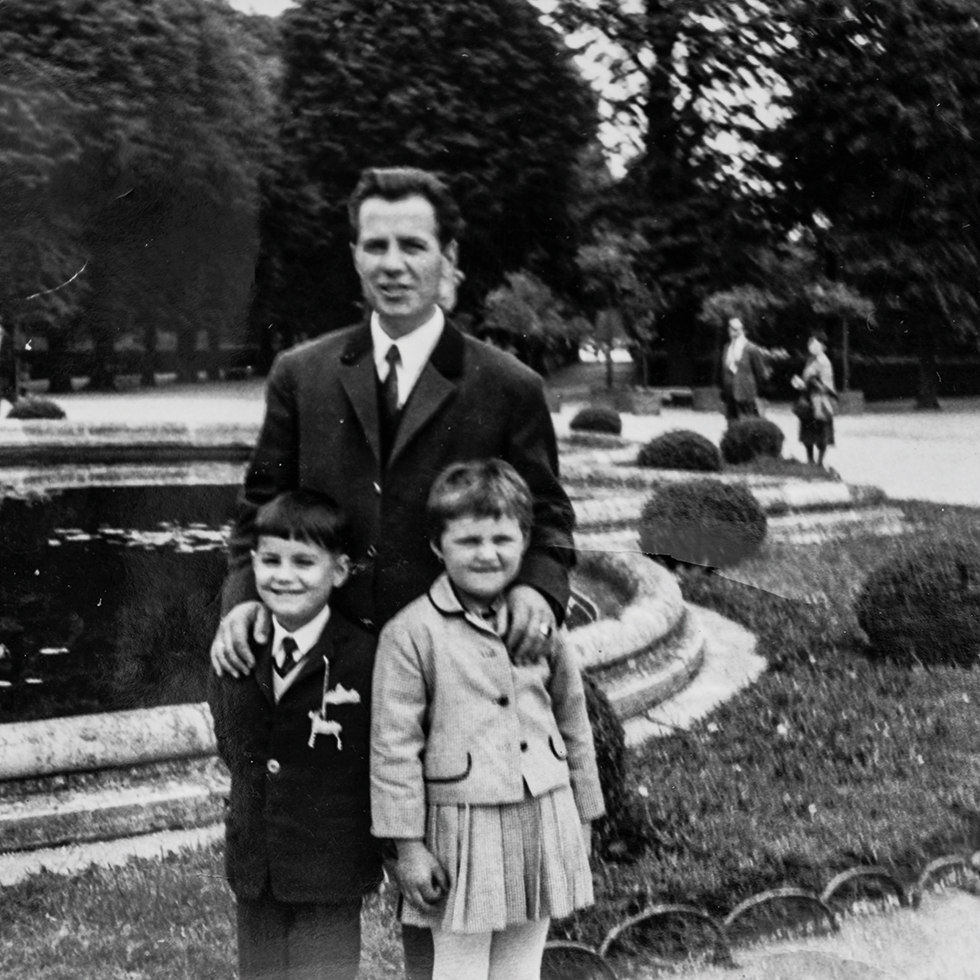 Schwarz-Weiß-Foto zum Vatertag mit Vater und zwei Kindern bei einem gemeinsamen Familienausflug im Park.