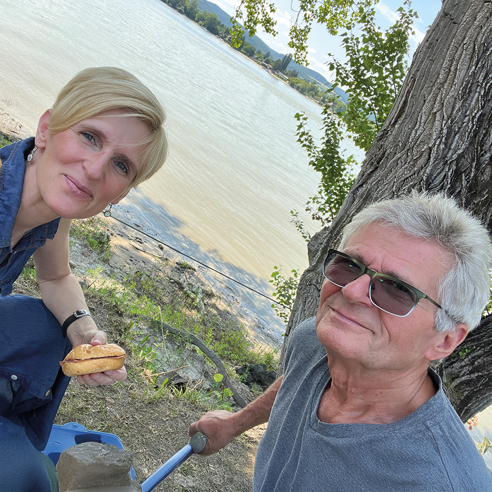 Vater und Tochter genießen eine gemeinsame Pause am Wasser und verbringen entspannte Zeit zum Vatertag in der Natur.