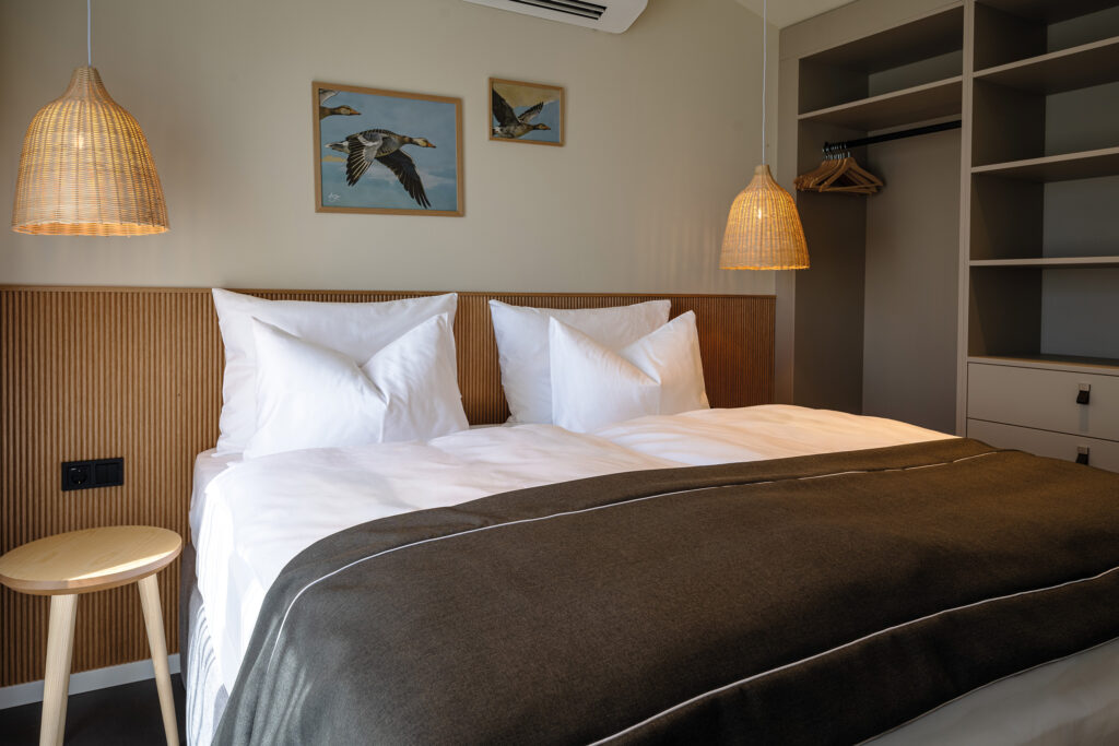 Stilvolles Schlafzimmer mit warmem Licht und hochwertigem Interior im neuen Guesthouse am See.
