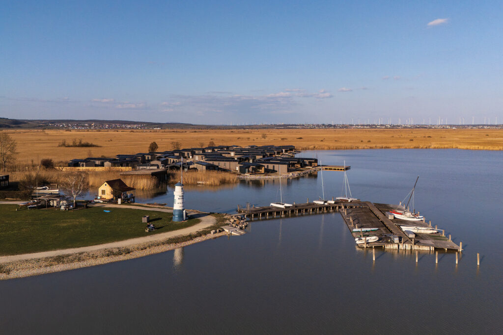 Neuer Strand: Luftaufnahme des neuen Strandareals mit Marina, Lodges und weitläufiger Seenlandschaft in Breitenbrunn.