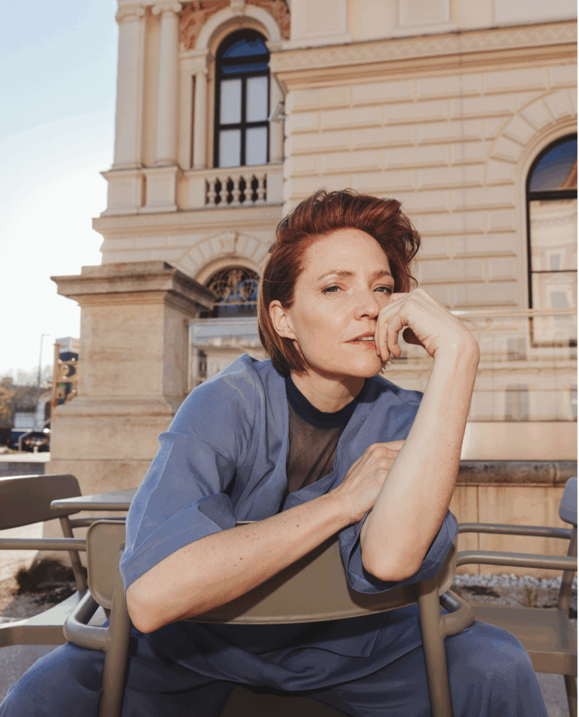 Porträtbild von Schauspielerin Patricia Aulitzky - sitzend mit Hand vorm Gesicht