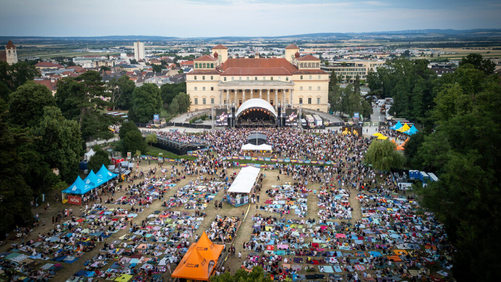 Events: Großes Open-Air-Konzert vor historischer Kulisse mit tausenden Gästen und weitläufigem Festivalgelände.