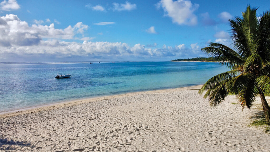 Traumhafter Sandstrand mit türkisblauem Wasser und Palmenküste auf Mauritius.