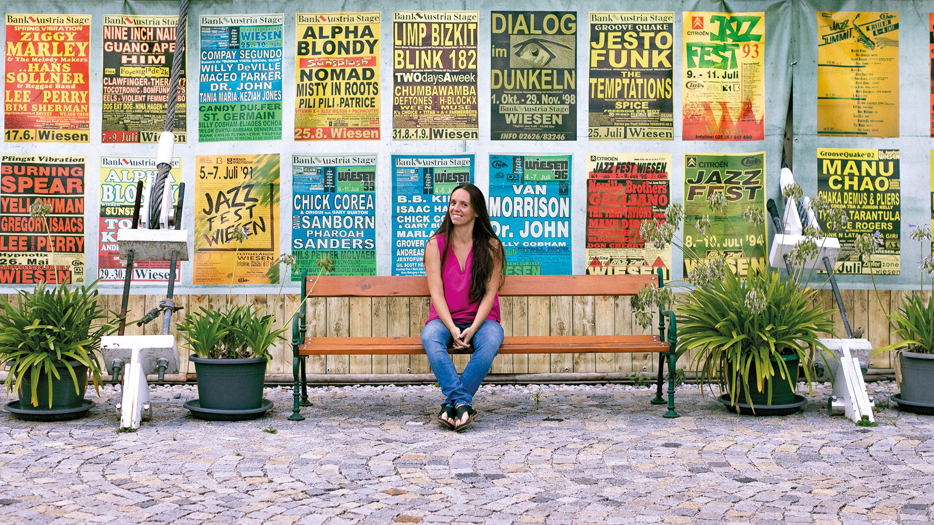 Juliane Bogner vor historischen Festivalplakaten in Wiesen – Erinnerung an Jahrzehnte internationaler Musikgeschichte im Burgenland.