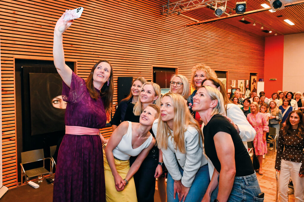 Teilnehmerinnen und Vortragende machen ein gemeinsames Selfie beim Longevity-Event vor Publikum.