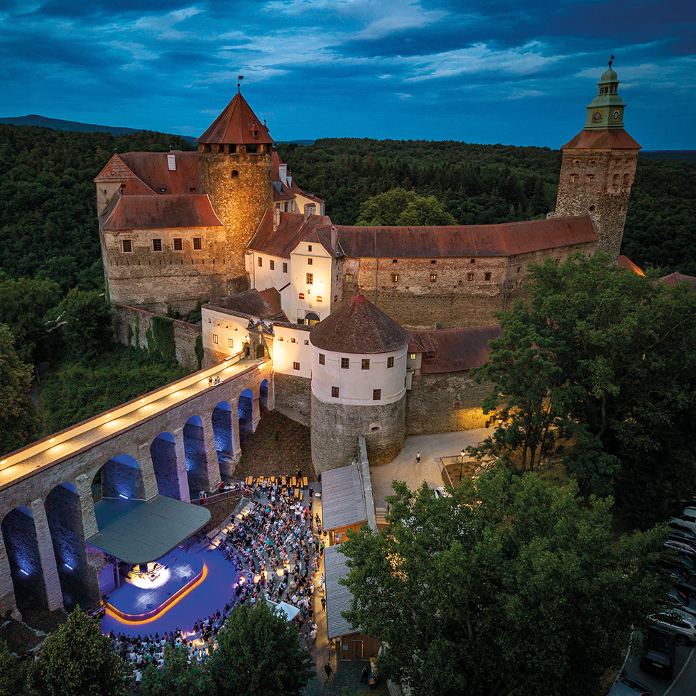 Die Friedensburg Schlaining bei Abendstimmung mit beleuchtetem Klangfestival im historischen Burghof.