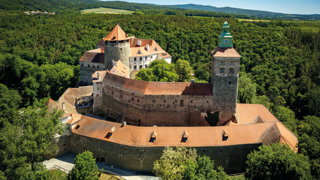 Luftaufnahme der Friedensburg Schlaining, umgeben von Wäldern und der imposanten mittelalterlichen Befestigungsanlage.