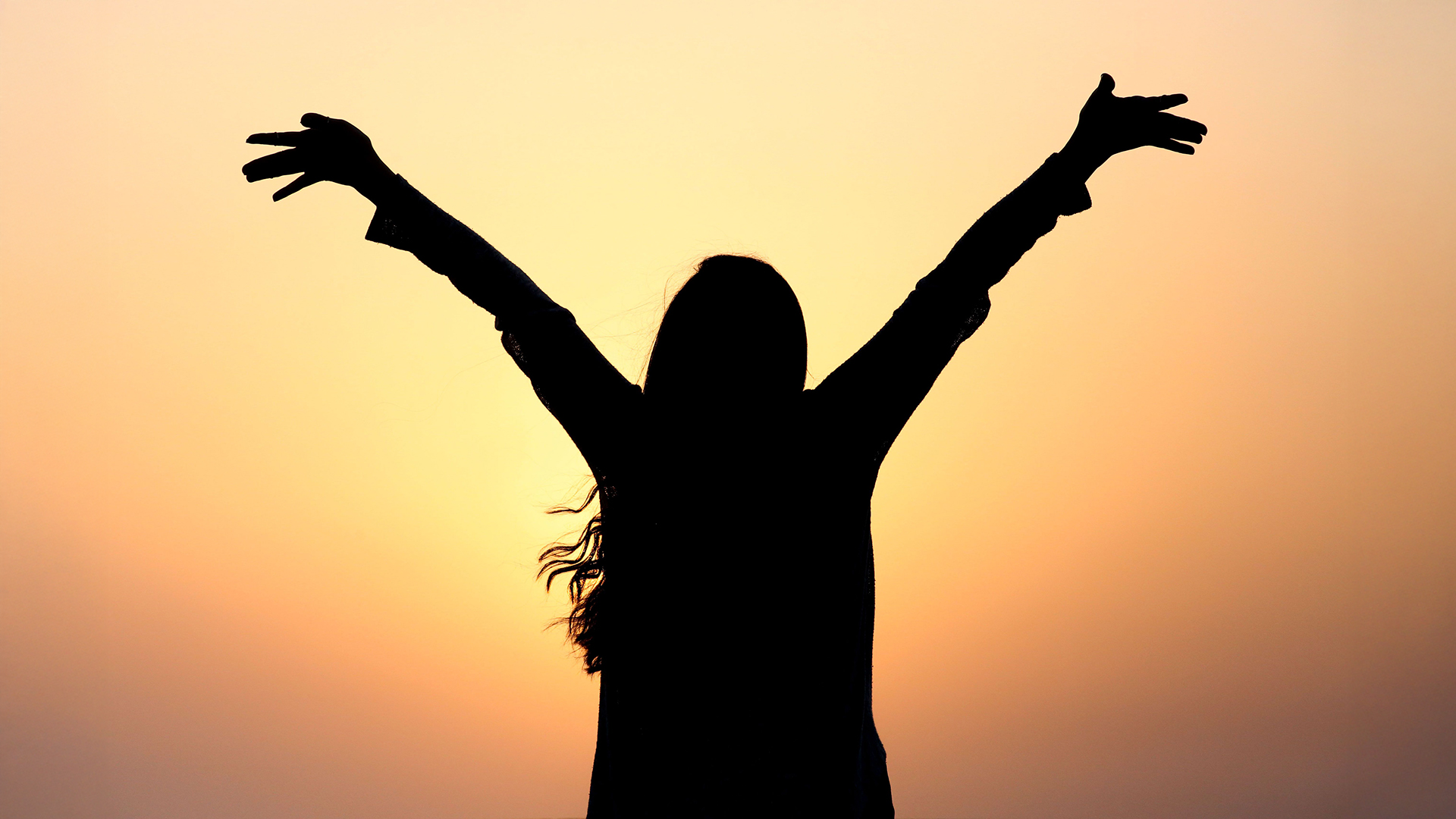 Top 100: Silhouette einer Frau mit ausgebreiteten Armen vor einem Sonnenuntergang – Symbol für Erfolg, Inspiration und die Top 100 Persönlichkeiten des Jahres.
