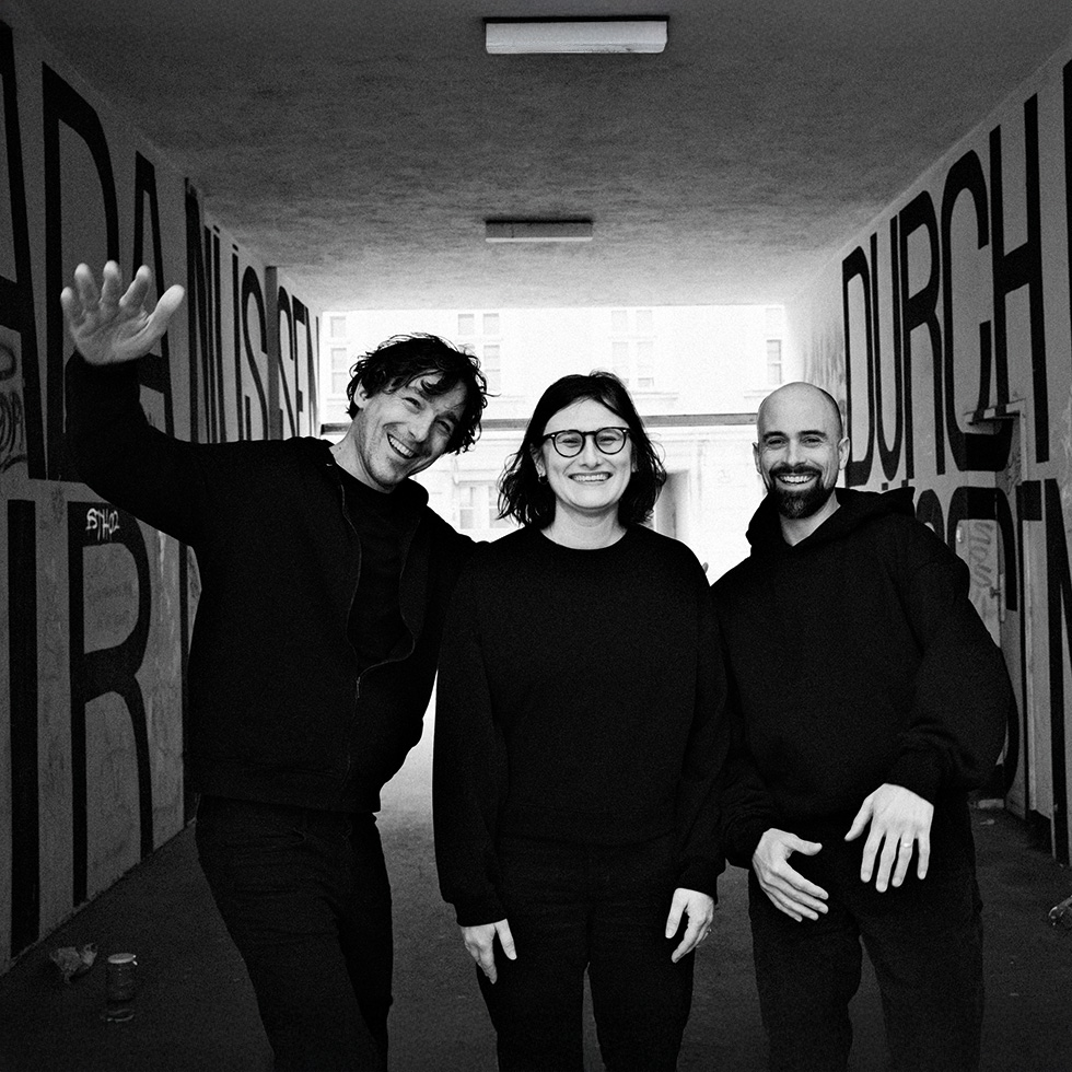 Kultur im September: Künstlerkollektiv bei einem Schwarz-Weiß-Porträt in urbaner Kulisse.