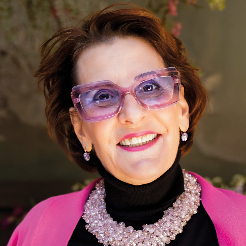 Pink Ribbon: Lächelnde Frau mit pinker Brille und pinkem Outfit als Unterstützerin der Brustkrebsinitiative.