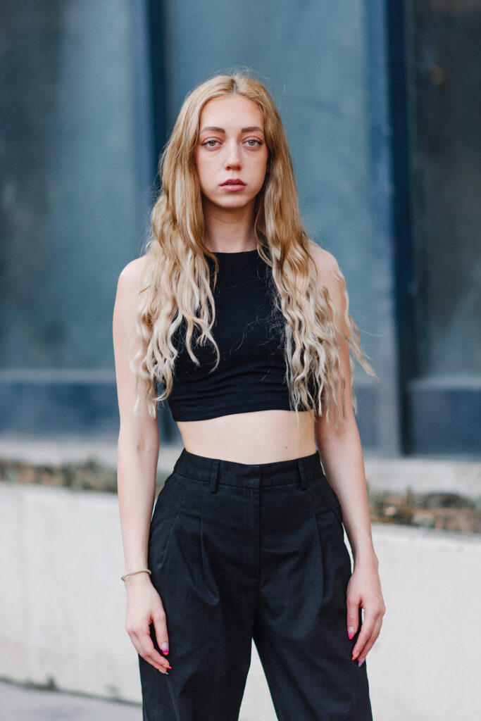 Porträt der Schauspielerin Selina Heindl mit langen blonden Haaren und schwarzem Outfit.