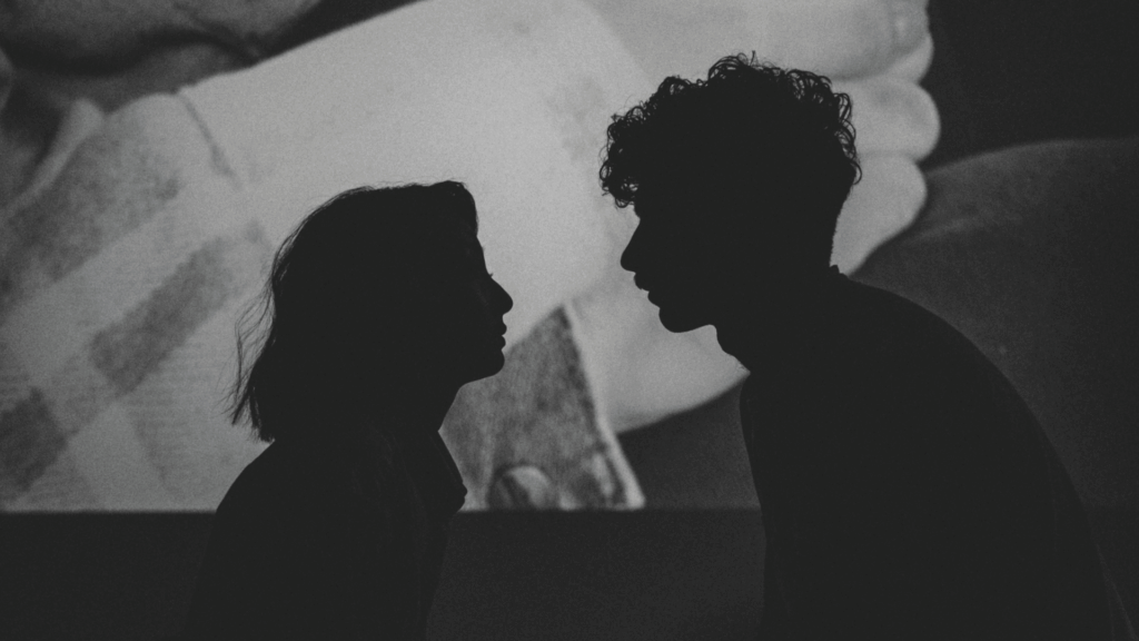 Silhouette von einer Frau und einem Mann, die sich ansehen mit Projektion im Hintergrund