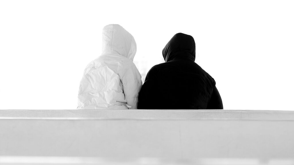 Böse: Zwei Personen in Schwarz und Weiß als symbolische Darstellung von Gegensätzen und der dunklen Seite des Menschen.
