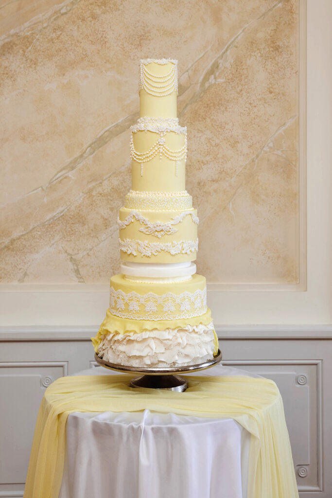 Hochzeitsshooting mit mehrstöckiger Hochzeitstorte in Creme und Weiß mit feinen Spitzendetails