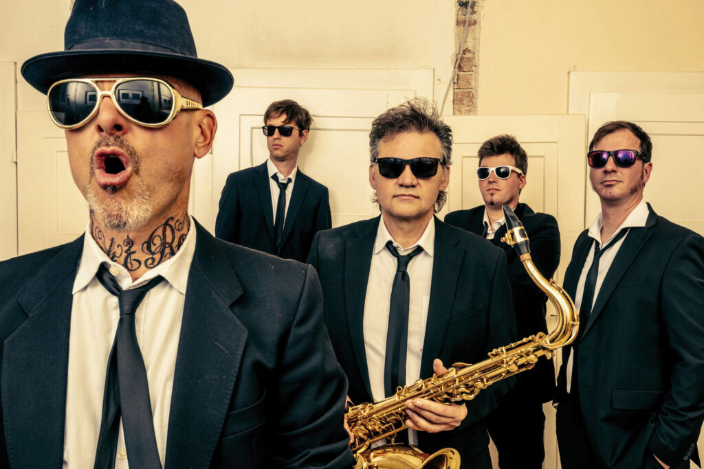 Oktober: Die Band "Die Präsidenten" mit Sonnenbrillen und Saxofon im Gruppenporträt.