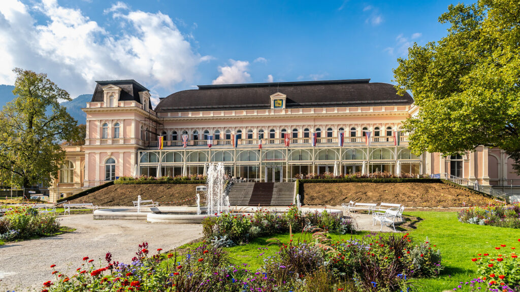 Alleinreisen in Bad Ischl: historische Trinkhalle mit Kurpark und Blumenbeeten.
