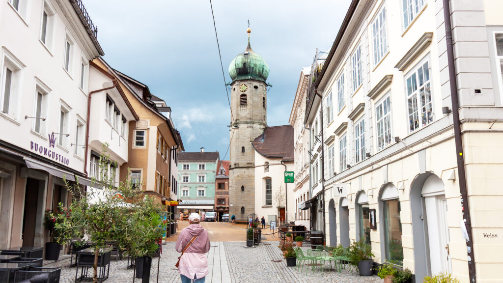 Alleinreisen in Bregenz: Frau erkundet die historische Innenstadt zu Fuß.