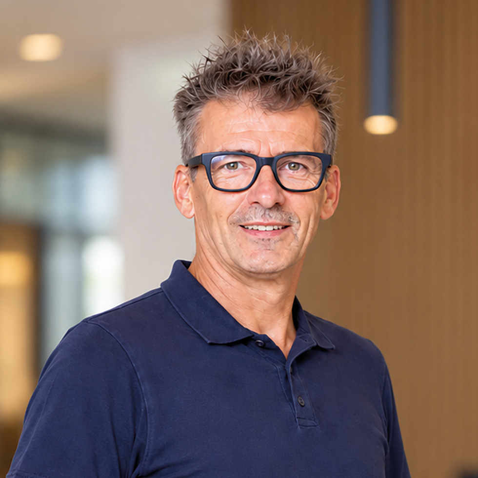 Porträt: Dr. Kluger vom Diagnosezentrum Eisenstadt mit Brille und dunkelblauem Poloshirt.